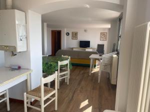 a kitchen and a living room with a table and chairs at Apartament 2 bedroom with one bathroom and penthouse Apartament 3 bedroom and 2 bathroom included with umbrella and sunbeds in Lido Adriano