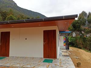 a building with two doors on the side of it at Budget couple rooms vattavada in Vattavada