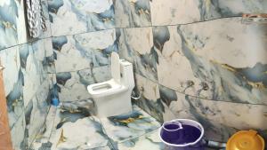 a bathroom with a marble wall with a urinal at Budget couple rooms vattavada in Vattavada