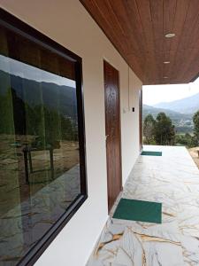 a room with a large window and a view of a mountain at Budget couple rooms vattavada in Vattavada +4 photos