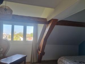 a bedroom with a bed and a large window at Sous les étoiles 1 in Cusset
