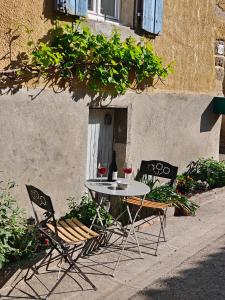 two chairs and a table with two glasses of wine at entre vignes et canal in Azille