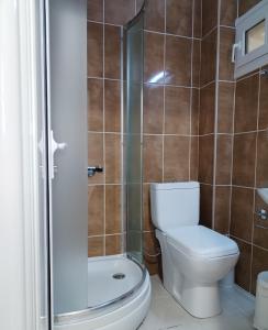 a bathroom with a toilet and a shower at Achilleas Apartments in Paralía Skotínis