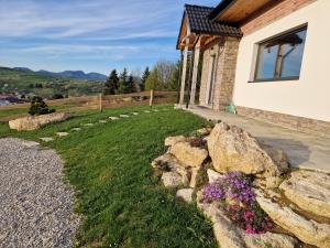 a house with a rock garden in the yard at Chata Elegant in Bešeňová
