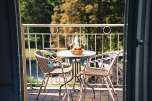 a table with two chairs and a bowl of fruit on a balcony at LU8 Business Vital Hotel in Bad Dürrheim