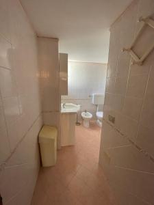 a small bathroom with a toilet and a sink at Apartament 2 bedroom with one bathroom and penthouse Apartament 3 bedroom and 2 bathroom included with umbrella and sunbeds in Lido Adriano +14 photos
