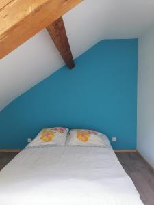 a bed in a room with a blue wall at Sous les étoiles 1 in Cusset