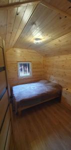 a bedroom in a log cabin with a bed in it at ChillWagon in Sieraków
