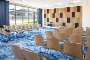an empty room with chairs and tables and windows at Parkest Hôtel & Spa in Genas +58 photos