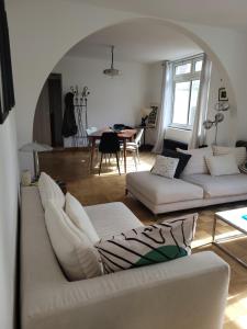 a living room with two couches and a table at Les Aigrettes - Appartement spacieux - Terrasse et garage in Concarneau