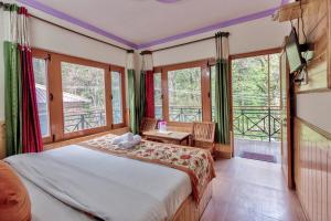 a bedroom with a bed and a balcony at Hotel Moonlight Manali in Manāli
