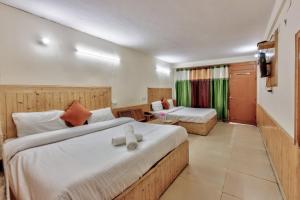 a hotel room with two beds and a couch at Hotel Moonlight Manali in Manāli
