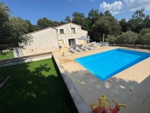 an image of a swimming pool in front of a house at Villa Bon Cavai in Mornas