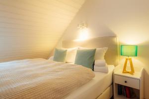 a bedroom with a white bed with a green lamp at Harzhygge Braunlage in Braunlage