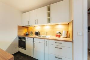 a kitchen with white cabinets and a sink at Harzhygge Braunlage in Braunlage