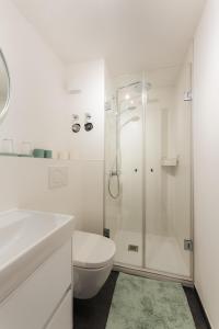a white bathroom with a shower and a toilet at Harzhygge Braunlage in Braunlage