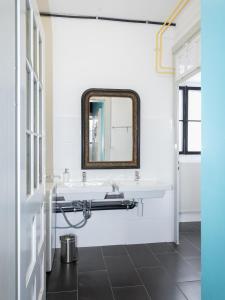 a bathroom with a sink and a mirror at La Colonie, former watch factory in Les Pommerats