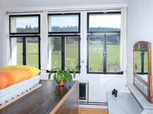 a bedroom with windows and a bed and a table at La Colonie, former watch factory in Les Pommerats