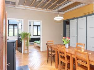 a kitchen and dining room with a wooden table and chairs at La Colonie, former watch factory in Les Pommerats