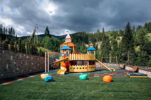 a playground with a slide in the grass at Gasthaus & Spa Bukovel in Bukovel