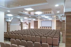 an empty room with a lecture hall with chairs and a screen at Gasthaus & Spa Bukovel in Bukovel +99 photos