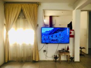 a living room with a flat screen tv on a wall at Cyrnos in Fez