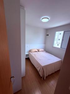 a small bedroom with a bed and a window at Espaço inteiro apartamento em Londrina in Londrina +3 photos