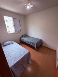 a bedroom with two beds and a window at Espaço inteiro apartamento em Londrina in Londrina