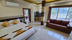 a bedroom with a large bed and a couch at White Dove Luxurious Boutique Hotel, within 3 Km from Guwahati Airport in Guwahati