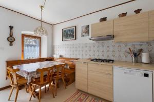 a kitchen with a table and chairs and a kitchen with a stove at Casa Carmen a Vinigo in Vinigo