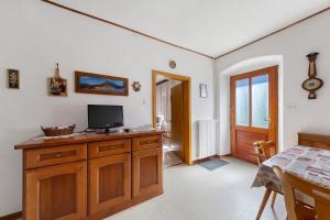 a living room with a television on a wooden cabinet at Casa Carmen a Vinigo in Vinigo