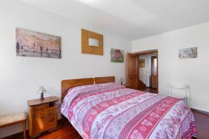a bedroom with a bed with a colorful bedspread on it at Casa Carmen a Vinigo in Vinigo