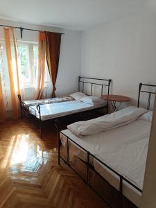 two beds sitting in a room with a window at Cazare muncitori Ploiesti -workers accommodation in Ţînţăreni