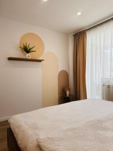 a bedroom with a white bed and a window at CentraLuxury in Piatra Neamţ