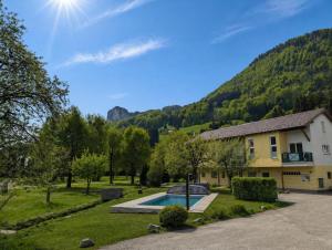 a house with a swimming pool in front of a mountain at Hotel Apartment Das Au- Gut in Hallein