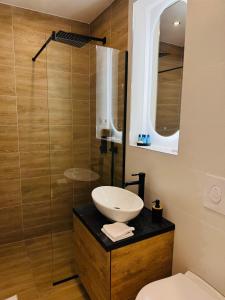 a bathroom with a sink and a glass shower at CentraLuxury in Piatra Neamţ +16 photos
