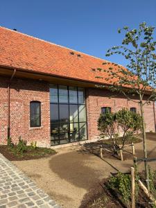 a red brick building with a large window at Tjusteplekske in Heuvelland