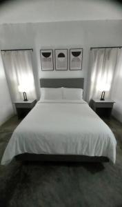 a bedroom with a large white bed with two lamps at Purevibe Horizon House Ocean View Villa Port Antonio in Port Antonio