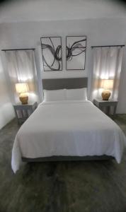 a bedroom with a large white bed and two lamps at Purevibe Horizon House Ocean View Villa Port Antonio in Port Antonio
