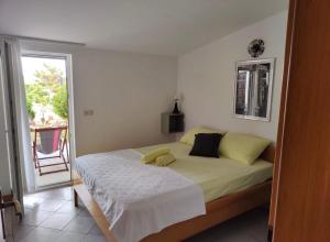 a bedroom with a bed with a yellow pillow on it at Apartments Gina in Trogir +112 photos