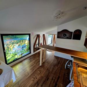 a living room with a table and a large screen tv at Wood Nest in Bragadiru