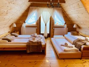 a bedroom with three beds in a attic at Ośrodek Wypoczynkowy Czerwienne Wzgórza in Czerwienne