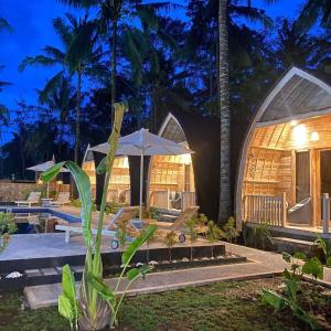 a villa with a swimming pool at night at Sari Lumbung Bungalow in Penginuman
