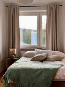 a bedroom with a bed with pillows and a window at POKLEKANE in Wysowa-Zdrój