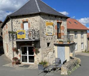a stone building with chairs in front of it at Chambres d'hôtes de l'Auberge L'Astrassadou in Rézentières