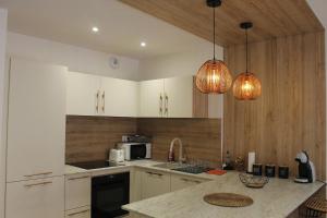 a kitchen with white cabinets and a counter top at Le Chevalier I - L'Écrin Alsacien in Sélestat +19 photos