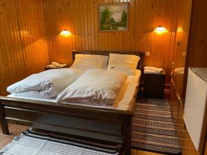 a bed with white sheets and pillows in a room at Guest house Nad Tisou in Kvasy