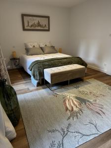 a bedroom with a large bed and a rug at Le Chevalier I - L'Écrin Alsacien in Sélestat