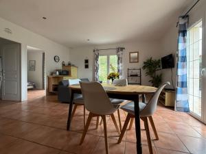 a dining room and living room with a table and chairs at Hacienda in Caumont