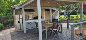 a house with a table and a kitchen on a deck at Villa du Rosais in Saint-Hilaire-de-Talmont